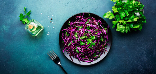 Wall Mural - Healthy food salad with red cabbage, carrot, parsley and olive oil dressing on white kitchen table background, top view