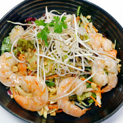 Wall Mural - thai style spicy shrimp salad with crunchy vegetables, peanuts and bean sprouts on white background, top view