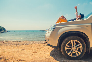 Wall Mural - happy woman at sea summer beach sitting at car hood