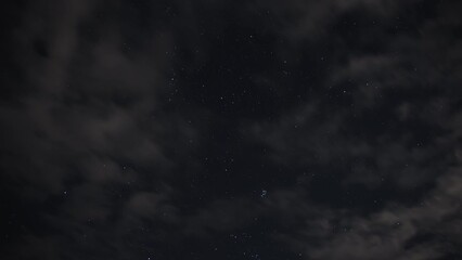 Wall Mural - Time Lapse of night starry sky covered with clouds.