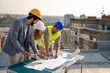 © NDABCREATIVITY - Construction concept. Engineers and architects working at construction site with blueprint