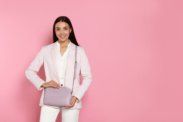 Wall Mural - Beautiful young woman with stylish bag on pink background, space for text
