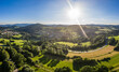 Luftaufnahme mit Drohne des Dorf Grueb bei Stadt Grafenau im bayerischen Wald mit Bergen und Landschaft im Sommer mit Sonne und Sonnenstrahelen, Deutschland