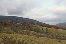 View Of A Hillside With Autumn Trees Against The Background Of The Cloudy Sky.