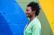 © VISTA by Westend61 - Smiling young woman in front of colorful wall