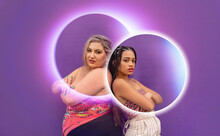Women Standing With Arms Crossed Seen Through Glowing Circles In Front Of Purple Wall
