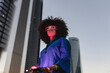 © VISTA by Westend61 - Red light falling on woman face wearing smart glasses in front of buildings
