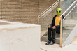© VISTA by Westend61 - Man wearing alien mask sitting on staircase
