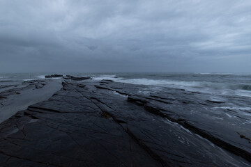 Wall Mural - Cloudy morning view on the rocky shore.