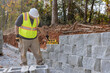 © ungvar - On new property where retaining block wall is being built construction worker is erecting block wall