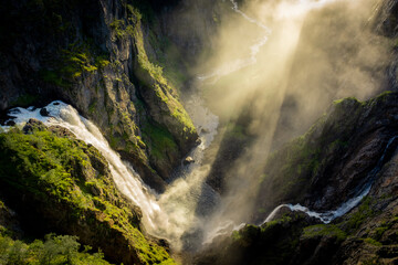 Wall Mural - Amazing sunbeams passing through the mist created by the Voringfossen  waterfalls, Norway