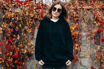 Wall Mural - Young woman in glasses and black hoodie