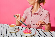 Young Woman Having Delicious Breakfast With Donut And Coffee Over Pink Background. Yummy