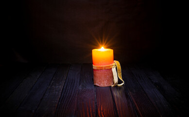 Vintage light candle on dark wooden table with copy space - celebration and Halloween background