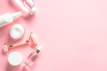 Fototapete - Natural cosmetics on pink. Skin care product, cream, soap serum, jade roller. Flat lay image with copy space.
