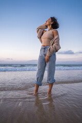 Wall Mural - Cheerful woman with tanned skin looking at the distance and enjoying of the ocean