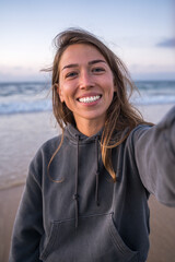 pov of the smiling brunette girl looking at the camera while standing at the ocean beach