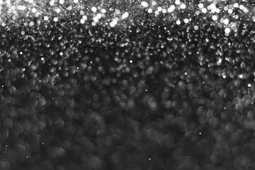 Wall Mural - Gray black sparkling glitter bokeh background, abstract defocused texture. Holiday lights. Snowy shiny sparkle stars for celebrate