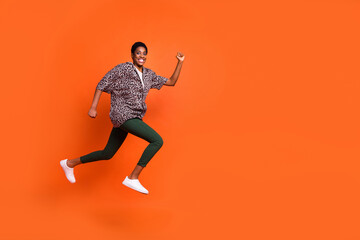 Full length body size view of attractive cheerful trendy girl jumping running motion copy space isolated on bright orange color background