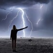 A woman stands in a field under a flash of lightning with her hands raised to the sky. Field with green grass. The last person on earth. Survivor.