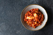 bowl with traditional korean kimchi fermented cabbage on dark table