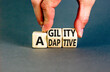 Agility and adaptive symbol. Concept words Agility and Adaptive on wooden cubes. Beautiful grey table grey background. Businessman hand. Business agility and adaptive concept. Copy space.