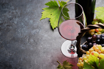 Red wine in glass, bottle and grapes in basket