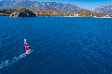 Wall Mural - Aerial top view of sailing boat move turquoise sea. Concept summer water sport trip