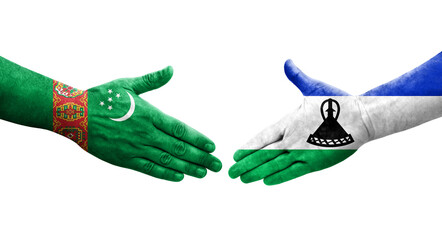 Handshake between Lesotho and Turkmenistan flags painted on hands, isolated transparent image.