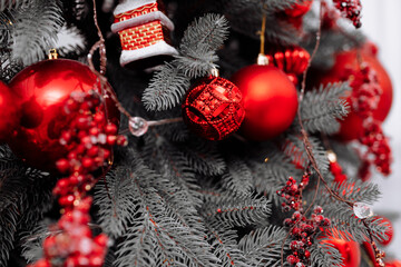 Sticker - stylish christmas decorations on the tree, beautiful toys, balls, cones and lights in red colours. Christmas cozy atmosphere in living room, new year. Festive interior design.