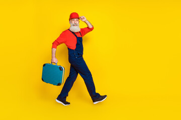 Wall Mural - Full size profile side photo of senior technician going hold equipment box isolated on bright color background