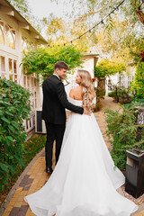 Wall Mural - newlyweds. groom and bride in traditional wedding clothes walk in park