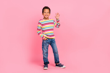 Canvas Print - Full length photo of positive sweet optimistic boy dressed striped shirt jeans arm in pocket wave palm isolated on pink color background