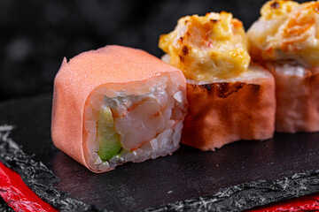 Canvas Print - Asian cuisine. Fukui rolls. Rice rice dough avocado fried tofu on a black background.