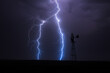 Lightning bolt strike and windmill silhouette in a thunderstorm