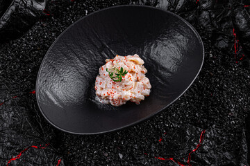 Sticker - Asian cuisine. Perch salad in a black plate on a black background.