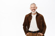 © Cookie Studio - Happy senior man with grey hair and beard, smiling white teeth, looking confident and carefree, posing against studio background