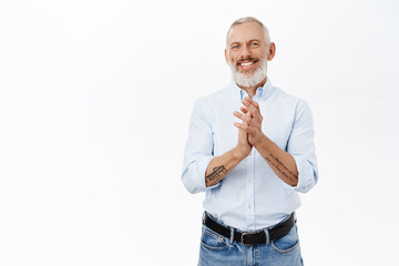 Handsome businessman, smiling senior man clap hands, applause and look pleased, standing over white background in blue shirt