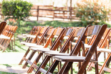 Rows of Wooden Event Chairs at Wedding Venue Abstract.