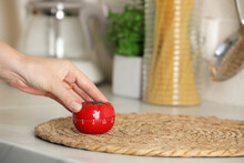 Woman Winding Up Kitchen Timer In Shape Of Tomato At White Table Indoors, Closeup. Space For Text
