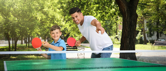 Poster - Man with his son playing ping pong in park. Banner design