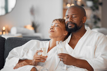 Mature Couple, Bonding And Champagne On Spa Date, Romantic Retreat Or Resort Holiday For Marriage Anniversary Celebration. Black Woman, Man And Alcohol Glass On Relax Salon Or Hotel Living Room Sofa