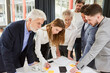 © Robert Kneschke - Business Leute vom Start-Up Team schauen auf Smartphone