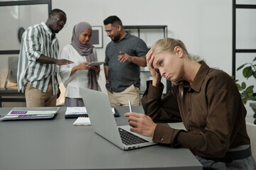 Aufkleber - Young tired businesswoman trying to concentrate during work over project while group of multicultural colleagues bullying her