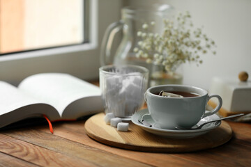 Poster - Tray with cup of freshly brewed tea and sugar cubes on wooden table, space for text