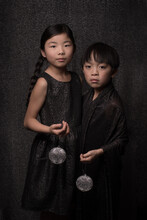Painterly Fine Art Portrait Of Girl And Boy In Black And Silver Holding Christmas Ornament