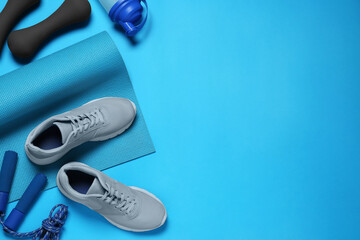 Poster - Exercise mat, shoes, dumbbells, shaker and skipping rope on turquoise background, flat lay. Space for text