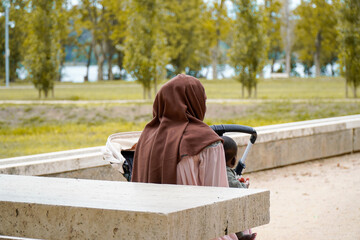 Wall Mural - Muslim black mommy with her baby in the park. Spanish migration