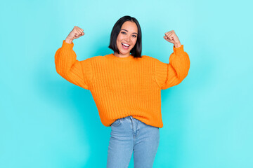 Sticker - Portrait of optimistic successful woman with bob hairstyle wear orange sweater clench fists up isolated on turquoise color background