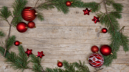 Christmas advent celebration holiday background greeting card - Frame made of pine branches, red christmas baubles balls and stars on rustic wooden table texture top view